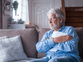 elderly man sitting in living room looking into the distance