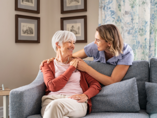 Adult daughter having a supportive conversation with her elderly mother about receiving support at home and maintaining independence as she is worried her elderly parent can no longer live alone.